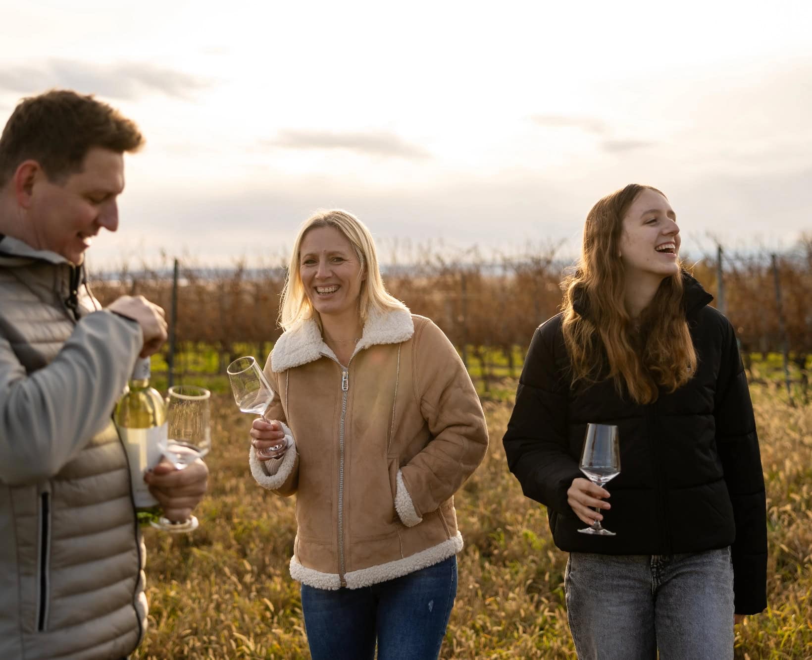 Familie Königshofer steht im Weingarten. Schöne Herbststimmung.