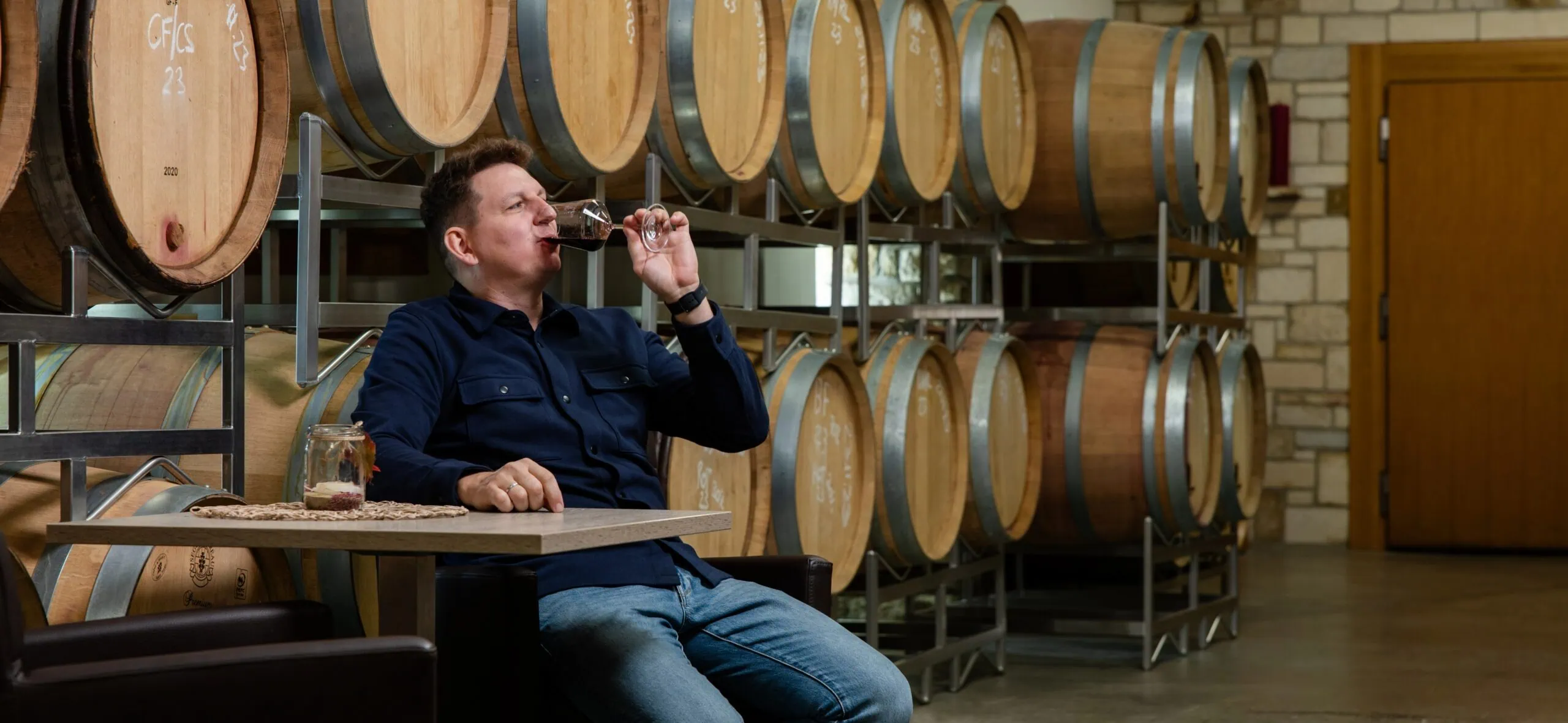 Weingut Koenigshofer Markus trinkt Rotwein im Barriqueraum